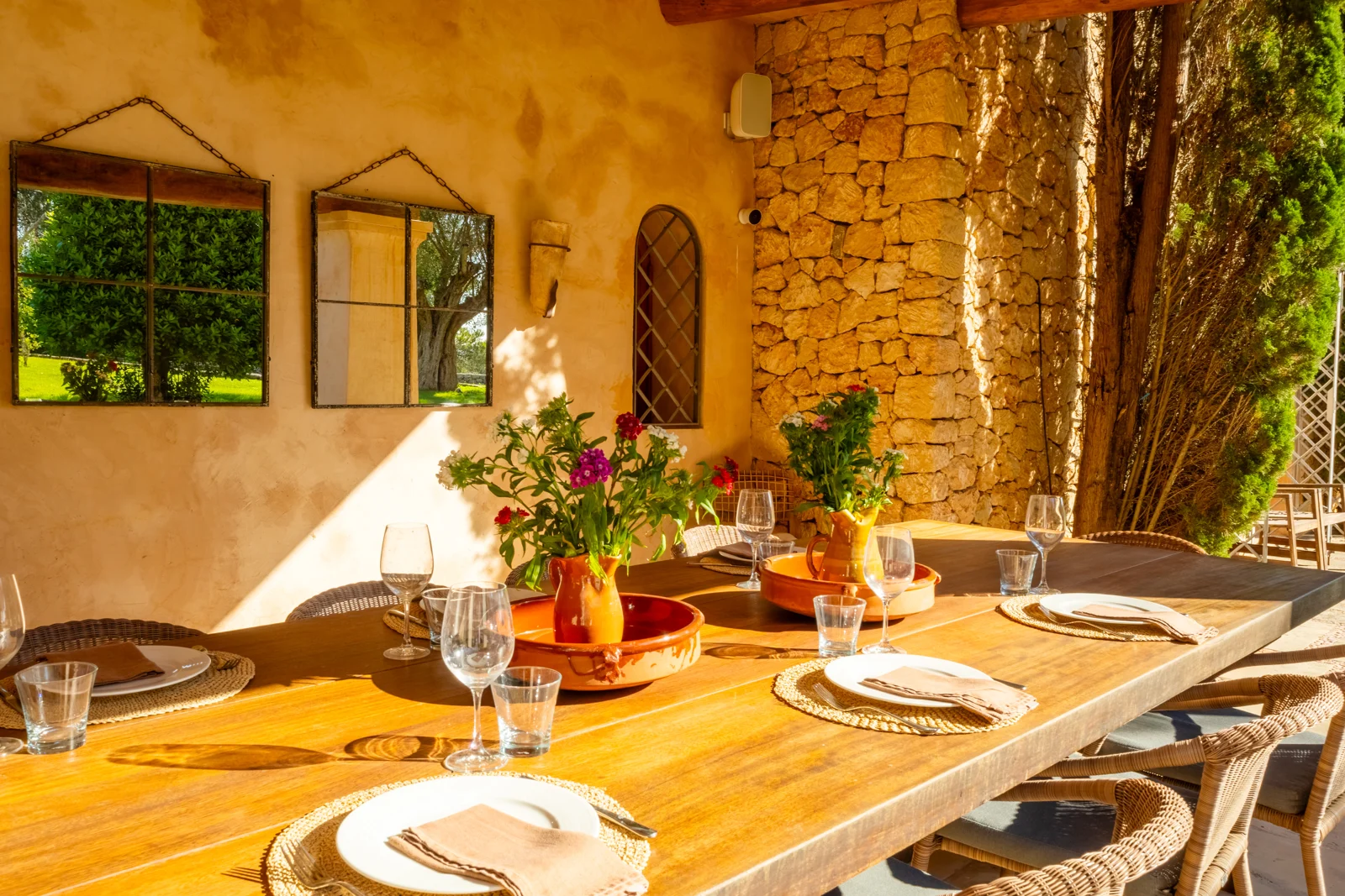 Warm stone walls and a sunlit table set for a gathering