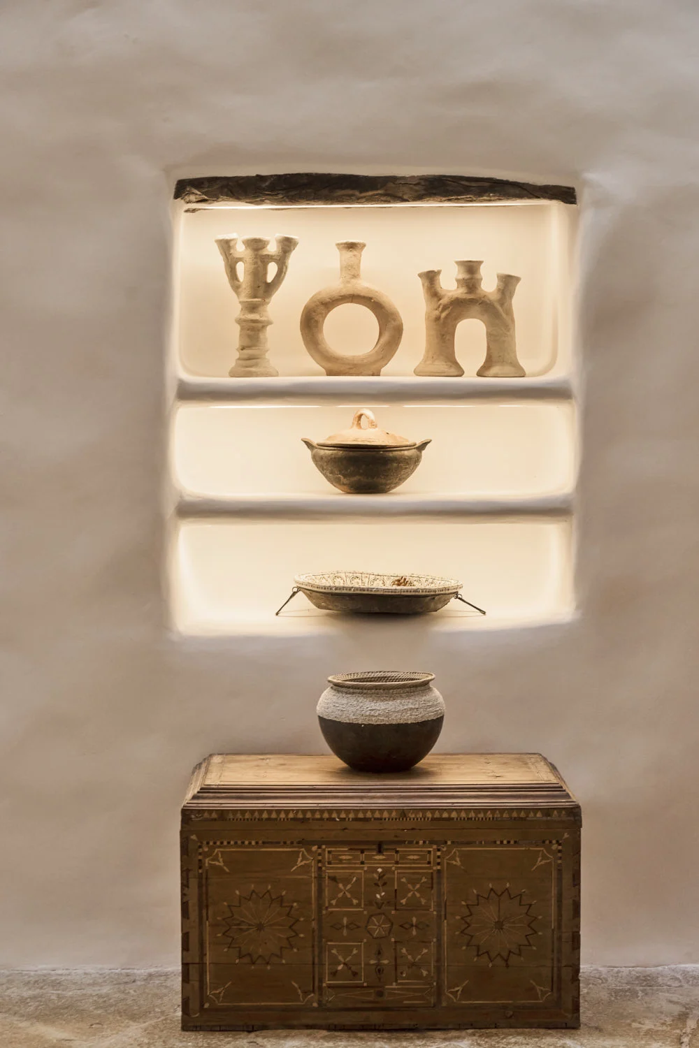 A collection of sculptural objects and vessels in a styled interior